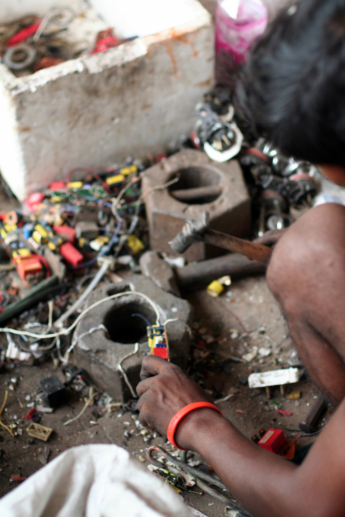 A man removes metal from circuit boards